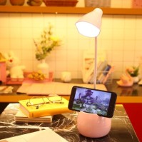 Pink USB LED desk lamp with pen holder base in use scene